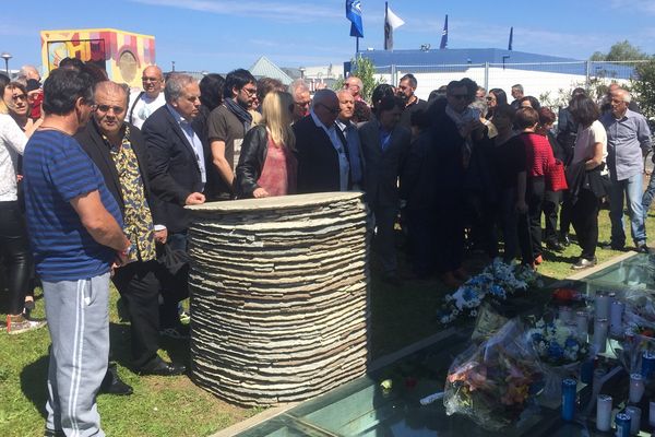 Des victimes, des familles de victimes et des anonymes réunis autour de la stèle au stade de Furiani, le 5 mai 2016.