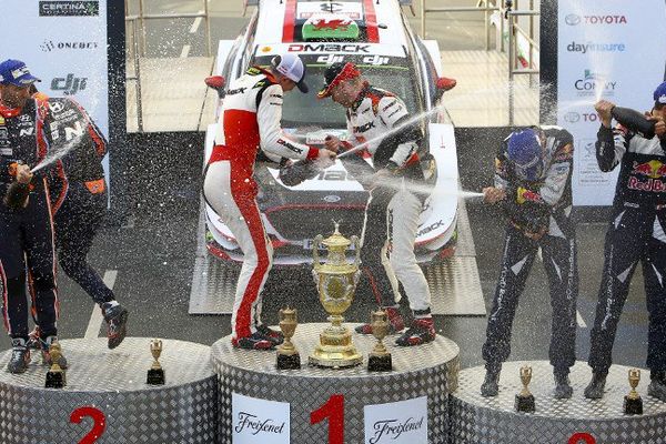 Sébastien Ogier et son co-pilote Julien Ingrassia sablent le champagne ( au centre de la photo)