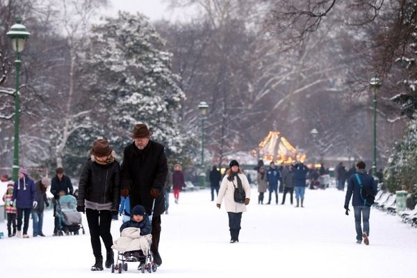 Des gens déambulent dans le parc Monceau sous la neige