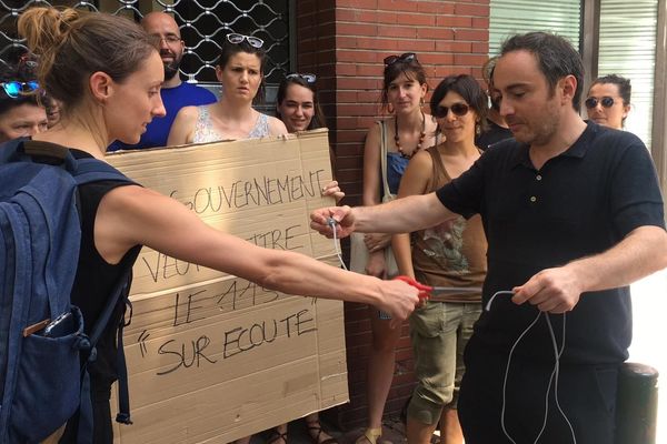 Symbole : les associations toulousaines liées aux hébergements d'urgence ont coupé un câble téléphonique. "Le gouvernement veut mettre le 115 sur écoute", indique leur pancarte. 