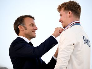 Le Président Emmanuel Macron et le nageur Léon Marchand, le 14 septembre 2024, lors de la parades des champions des JO de Paris 2024.