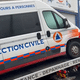 L'ambulance dégradée est hissée sur un véhicule de dépannage.