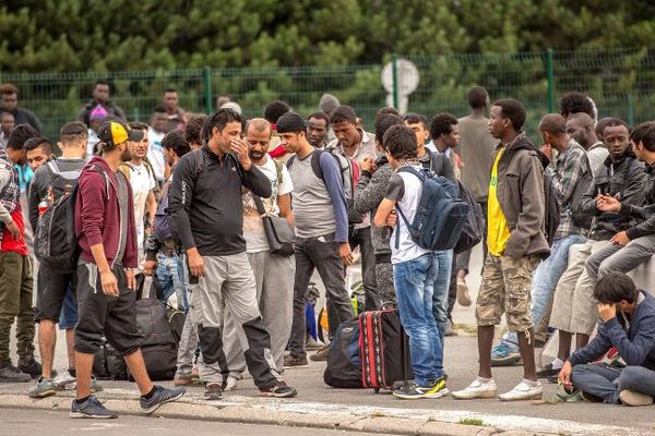 Des migrants de Calais qui attendent le bus pour rejoindre un CAO. 