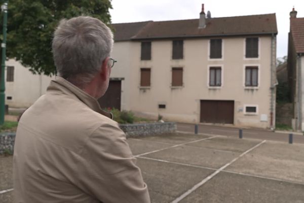 Philippe Balizet, le maire de Chaux, se tient devant les deux maisons où étaient hébergés les 70 vendangeurs espagnols.