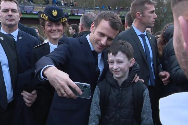 Emmanuel Macron enchaîne les selfies dans les rues d'Angoulême, protégé par un important dispositif de sécurité.