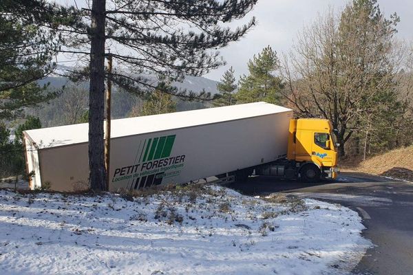 Ce camion s'est couché sur la route à cause de la neige et du verglas.