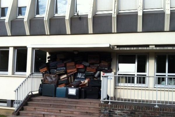 Les membres d'Emmaüs ont dressé un mur de valise devant l'URSAFF d'Arras.