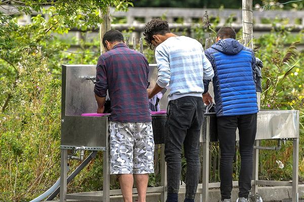 Des migrants sur un point d'eau, à Calais, en 2017.