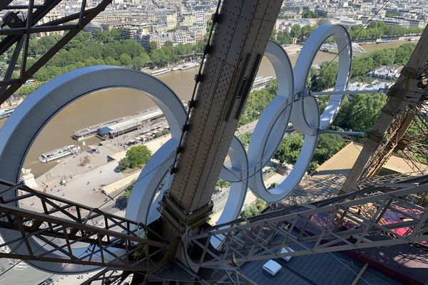 Les anneaux olympiques fabriqués notamment par les usines Industeel d'ArcelorMittal, suspendus à la Tour Eiffel.