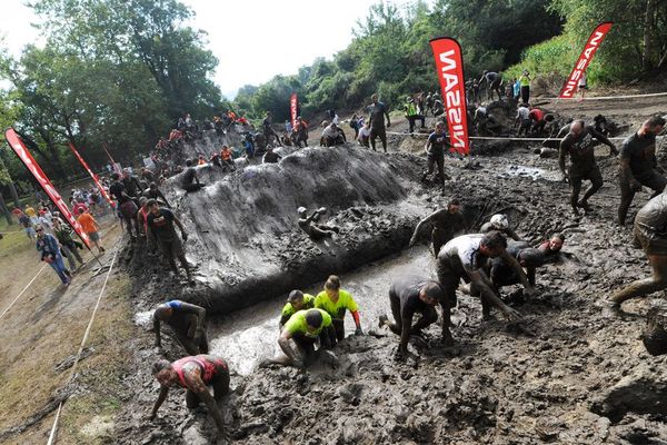 Des Mud Guys franchissant l'obstacle "Cross over mud mountains" lors du "Mud Day Lyon 2014" au Lac de Vénérieu