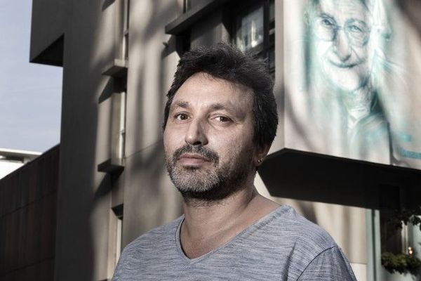 L'artiste C215 devant le portrait de Soeur Emmanuelle réalisé en 2017 à Paris