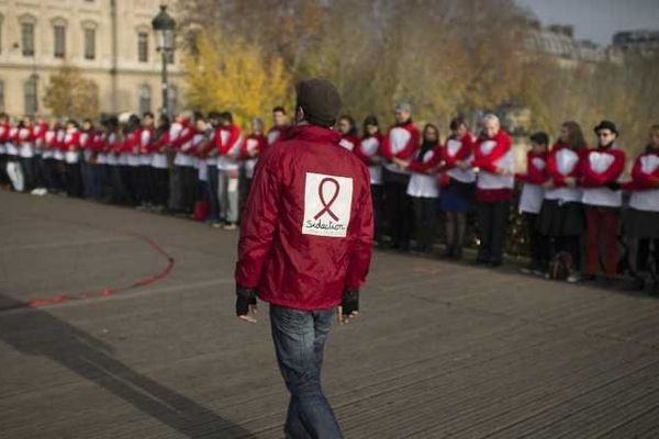 Des bénévoles de Sidaction organisent une chaîne de solidarité, le 30 novembre 2014 sur le Pont des Arts à Paris.