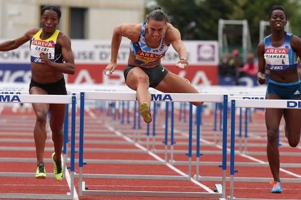 Reina Flor Okori (à gauche) termine deuxième de la finale du 100m haies aux Championnats de France d'athlétisme à Reims, battue par Cindy Billaud (au centre), le 12 juillet 2014.