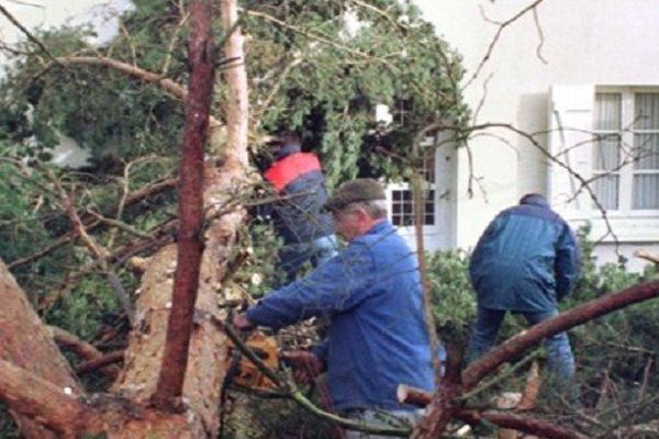 Ouvriers découpant un arbre bloquant l'accès à une maison au mas Gauthier près de Limoges le 28 décembre 1999