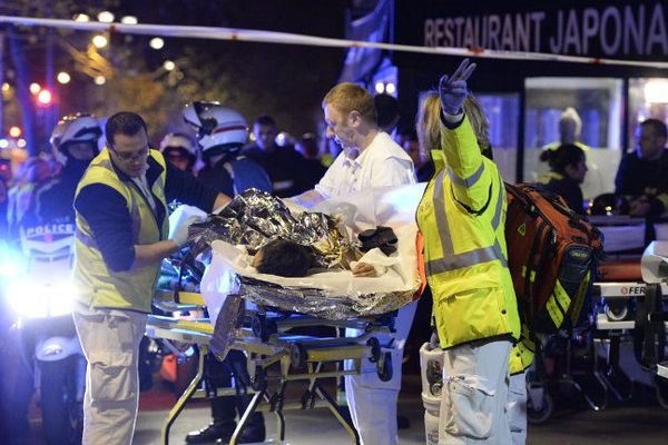 13 novembre 2015, les secours évacuent un blessé à proximité du Bataclan à Paris, après une série d'attentats qui a fait au moins 120 morts dans la capitale.