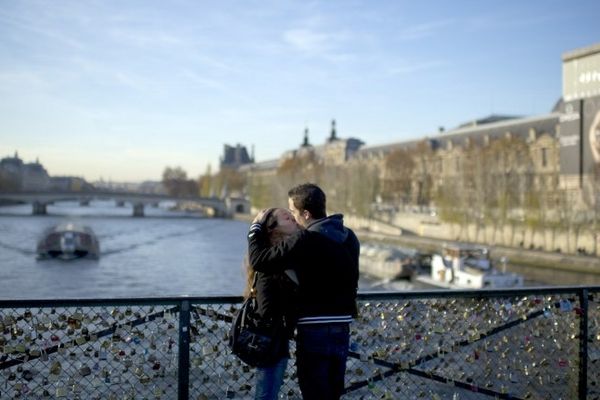 Un couple s'embrasse sur le Pont des Arts à Paris