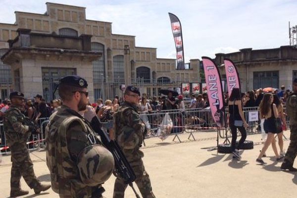 Des militaires patrouillent devant la Halle Tony Garnier, alors que des fans attendent pour le concert d'Ariana Grande.