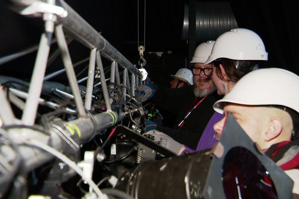 Dans la salle du 9 Cube à Châteauroux, les régisseuses et régisseurs de production installent le plan lumière d’un concert fictif.