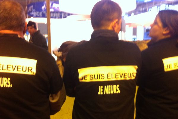 Les éleveurs vêtus d'un tee shirt noir pendant la visite de François Hollande