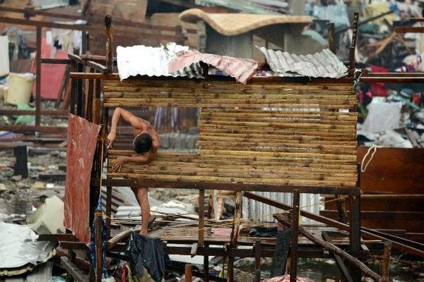 Un homme reconstruit sa maison détruite par le typhon Haiyan à Taboclan -  12 Nov 2013