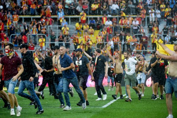 Des supporters lensois sur la pelouse du stade Bollaert-Delelis lors de la mi-temps du derby du Nord, ce samedi 18 septembre.