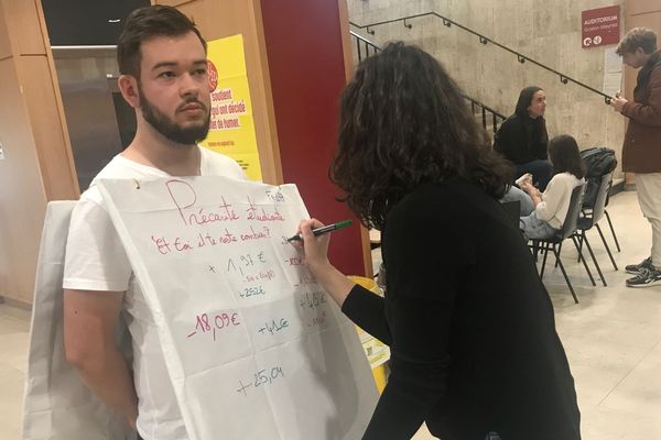 Ce mardi 26 novembre, Thibaud Mazzia, président de la FedEA (Fédération des Etudiants d'Auvergne) s'est improvisé en homme-sandwich dans le hall de sa Faculté pour que les étudiants y inscrivent le montant de ce qu'il leur reste pour vivre en cette fin de mois.  