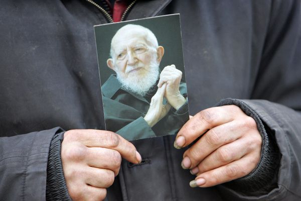 Une personne sans domicile fixe tenant une photo de l'Abbé Pierre le jour de ses funérailles, le 26 janvier 2007.