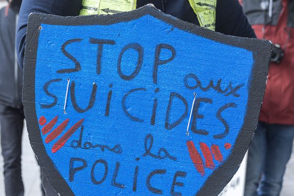 Une pancarte en forme de bouclier : "Stop aux suicides dans la police"