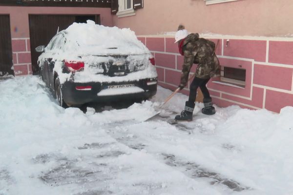 Une habitante déneige autour de sa voiture à Lutter (Haut-Rhin), vendredi 22 novembre.