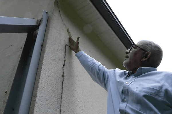 Mohamed Benyahia, président de l'association Urgence Maisons Fissurées-Sarthe, montre une fissure sur sa maison, causée par le retrait-gonflement de l'argile. Ces dégâts s’aggravent chaque année, sans possibilité d’indemnisation