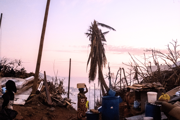 À Mayotte, des femmes transportent de l'eau dans les débris laissés par le passage du cyclone Chido