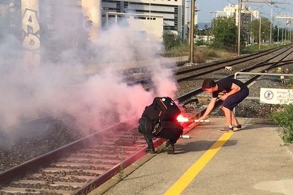 Des manifestants en train de déposer des fumigènes sur le quai de la gare de Nice Saint-Augustin.