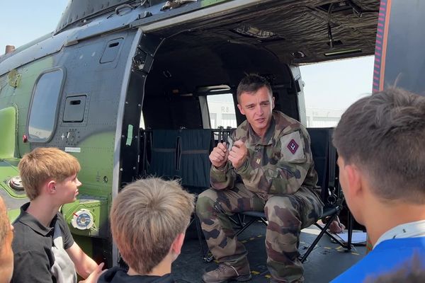 Attention maximale pour les collégiens qui écoutent les consignes avant le vol à bord d'un hélicoptère de combat.