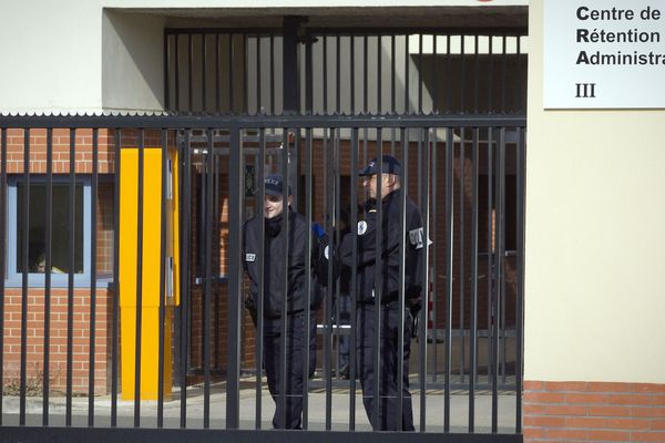 Des policiers derrière l'entrée du Centre de Rétention Administrative (CRA) du Mesnil-Amelot (Seine-et-Marne).