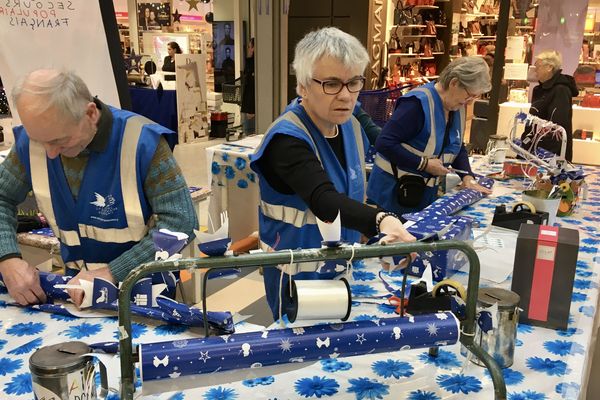 Depuis le 24 novembre, les bénévoles du Secours populaire emballent les cadeaux pour récolter des dons, comme ici à côté de Saint-Brieuc, dans la galerie commerciale d'un supermarché