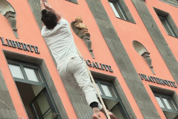 Une performance de mât chinois sur la façade de l'Hôtel de Ville, lors de la cérémonie d'ouverture.