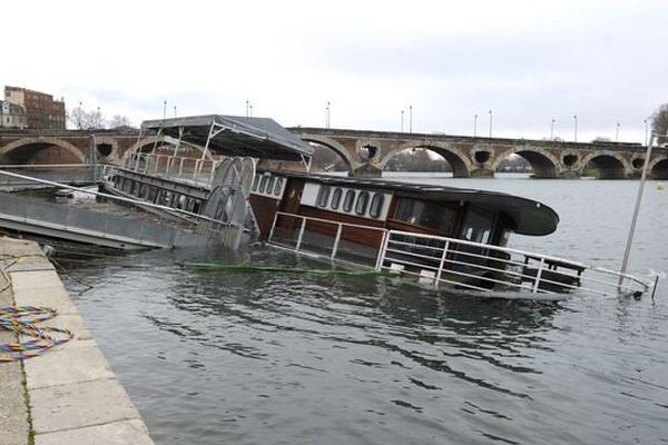 La péniche est amarrée, semi-immergée, quai de la Daurade à Toulouse.