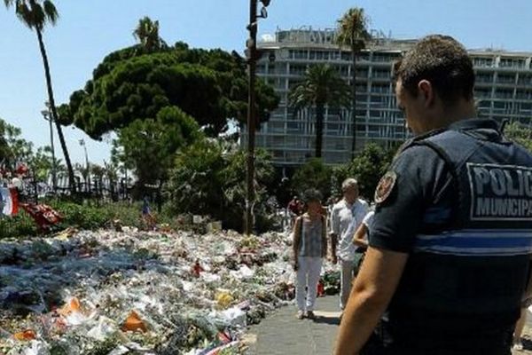 Un policier municipal se recueille sur la promenade des Anglais à Nice, le 25 juillet .