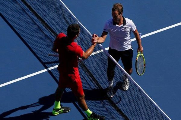 A New York, le sérignanais Richard Gasquet serre la main de l'australien Bernard Tomic qu'il a battu 6-4, 6-3, 6-1
à l'US Open 2015, samedi soir.