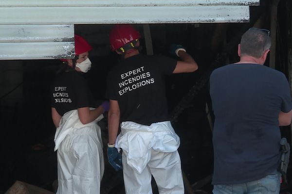 Les experts de la police scientifique tentent de déterminer les causes de l'incendie d'une boucherie/boulangerie jouxtant le nouveau poste de police du quartier de Pissevin à Nîmes.