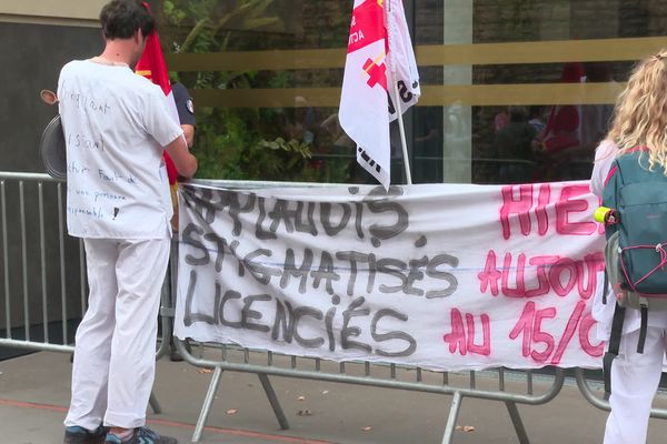 "Applaudis, stigmatisés, licenciés" indique un slogan placardé devant l'entrée de l'ARS Auvergne Rhône-Alpes par des manifestants ce mardi 14 septembre 2021, à la veille de l'entrée en application de l'obligation vaccinale pour les soignants.