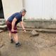 Cette habitante de Thiers nettoie la boue accumulée devantr chez elle. Deux jours après le violent orage qui s'est abattu sur la commune, samedi 20 juillet.