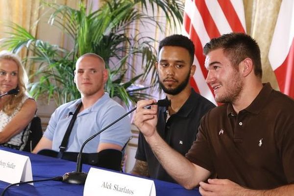 Les Américains Spencer Stone, Alek Skarlatos -deux soldats en vacances- et leur ami Anthony Sadler aux côtés de l'ambassadrice américaine, le 23 août 2015. - AFP PHOTO / THOMAS SAMSON