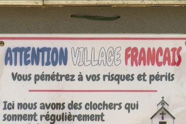 Un morceau du panneau posé aux entrées du village