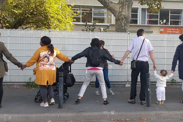 Des parents de Saint-Denis forment une chaîne humaine devant une école de Saint-Denis, début septembre.