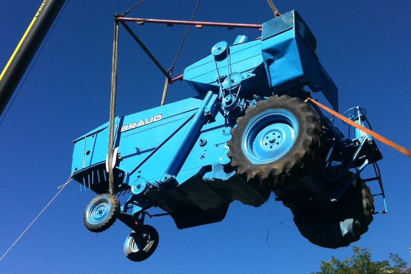 La moissonneuse batteuse bleu dans les airs de Teillé lors de la mise en place