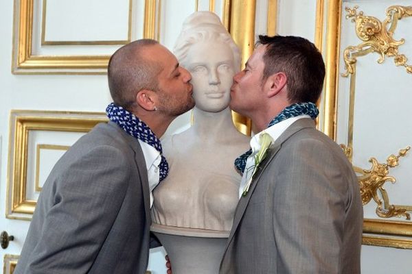 Un couple d'hommes embrasse symboliquement Marianne à la Mairie de Strasbourg le jour de leur mariage le 15 juin 2013