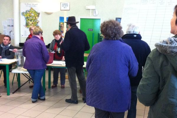 Des électeurs dans un bureau de vote de La Guerche-sur-l'Aubois, dans le Cher, le dimanche 29 mars 2015.