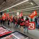 Des salariés d''Auchan défilent dans un hypermarché de leur enseigne à la Défense.