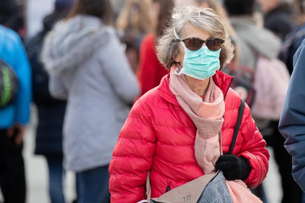 Une passante portant un masque devant le Louvres, à Paris - Photo d'illustration